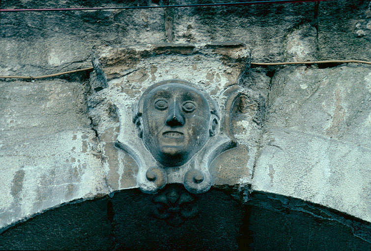 Façade antérieure des arcades : clef figurée.