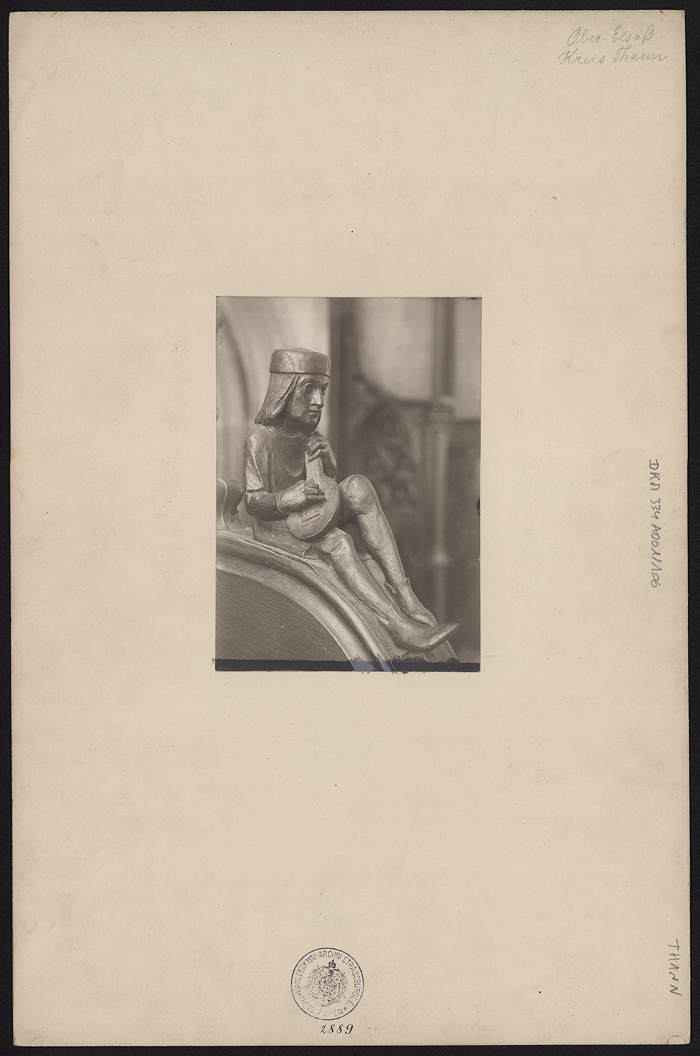 Vue de détail d’une statuette de musicien d’une parclose des stalles basses.
