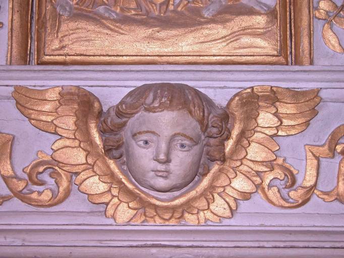 Tête d'angelot au soubassement de l'armoire eucharistique.