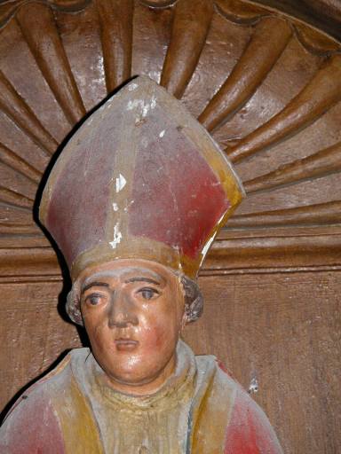 Statue de saint évêque dans la niche gauche du retable : détail du visage.