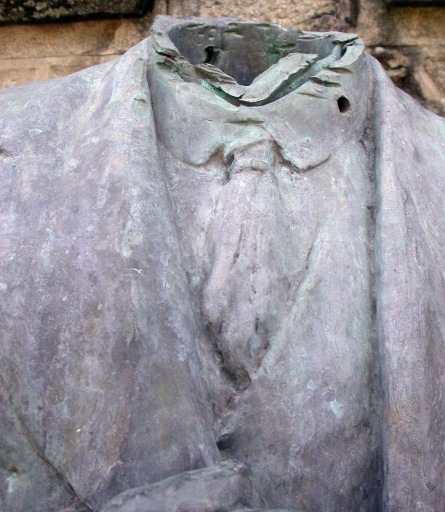 Détail du buste, avec les traces d'arrachage de la tête, et d'une balle traversante sur le col.