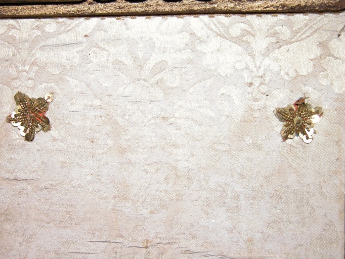 Détail d'un des carrés de tissu différent, orné de paillettes, rapportés dans les angles supérieurs.