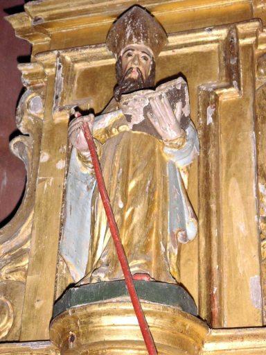 Statuette de saint évêque barbu sur le culot d'amortissement de l'aile gauche du tabernacle, vue en contre-plongée.