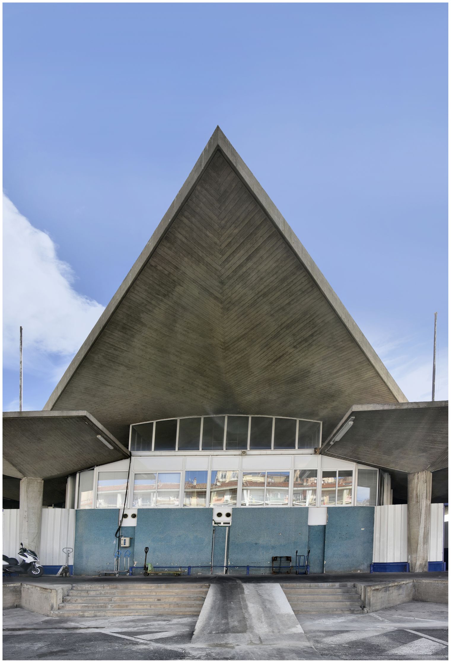 Façade principale. Partie centrale contenant la salle de la criée, soulignée par une grande pointe triangulaire.