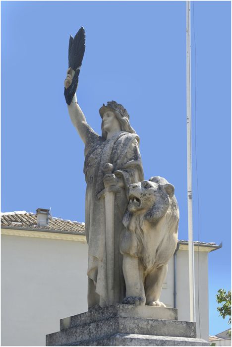 La statue. Allégorie de la France, appuyée sur une épée, levant la plame du martyr et accompagnée d'un lion. Œuvre de Jean Magrou.