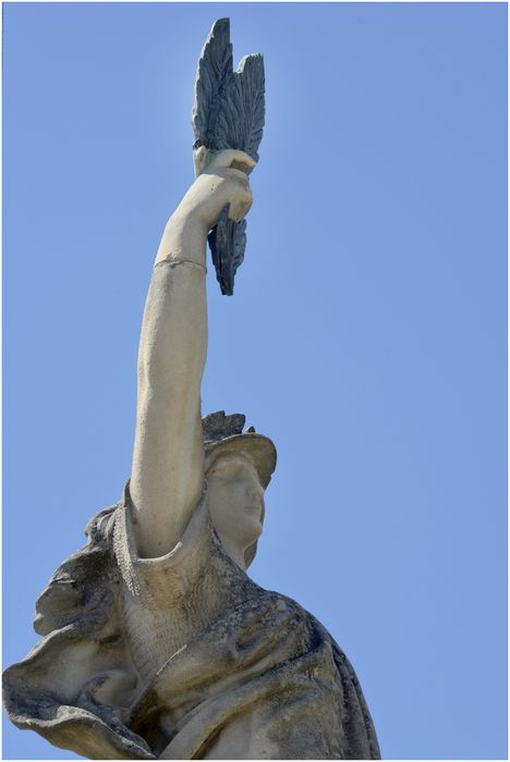 La statue. Détail de la cuirasse et du bras levant la palme.