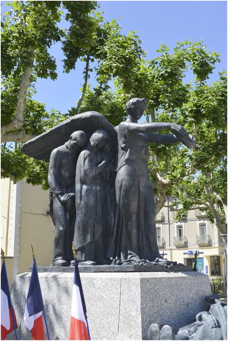 La victoire s’avance avec sa couronne vers le mort et protège sous ses ailes la population de la Grand Combe : deux mineurs torse nu, avec une lampe de mineur accrochée au ceinturon et un long pic de mineur. De l’autre coté un vieillard, une femme portant un bébé et à l’arrière deux enfants ferment la composition avec des palmes.