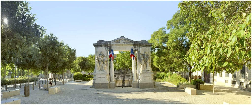 Vue d'ensemble du monument. Arc de triomphe dont le portique est décoré de chaque côté par des sculptures.