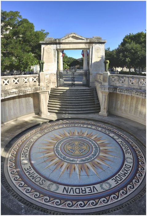 Crypte. Le sol est décoré d'une mosaïque centrée sur la croix de guerre qui rayonne tel un soleil vers le nom des batailles et des régions, l’ensemble aux tons pastel est dû à Patrizio et frères de Marseille.