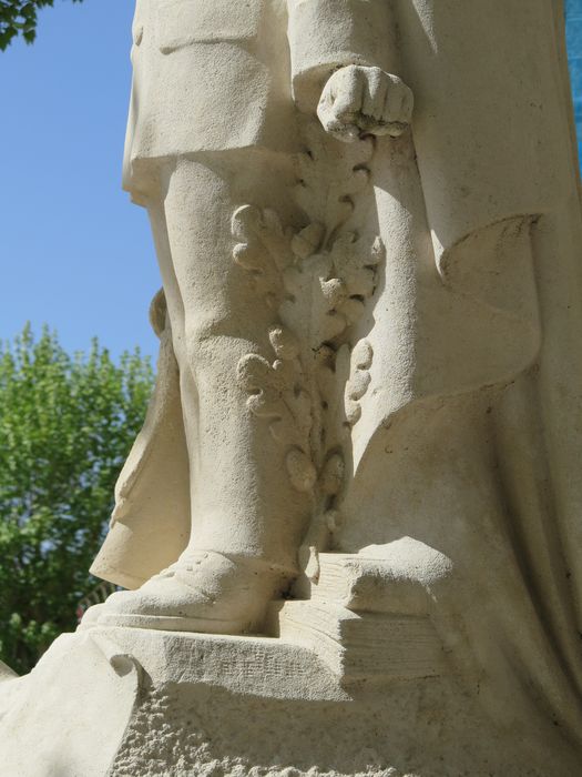 Groupe sculpté. Profil. Détail de la pile de livres et branche de chêne.