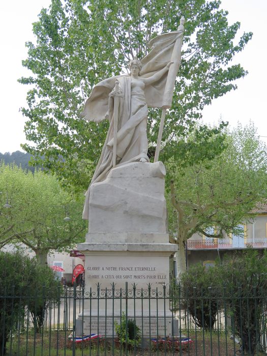 Vue d'ensemble sur une vaste place face au temple et dans l’axe de la rue menant vers la mairie.