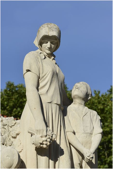 Groupe sculpté. Femme et enfant près d'une croix. Vue latérale.