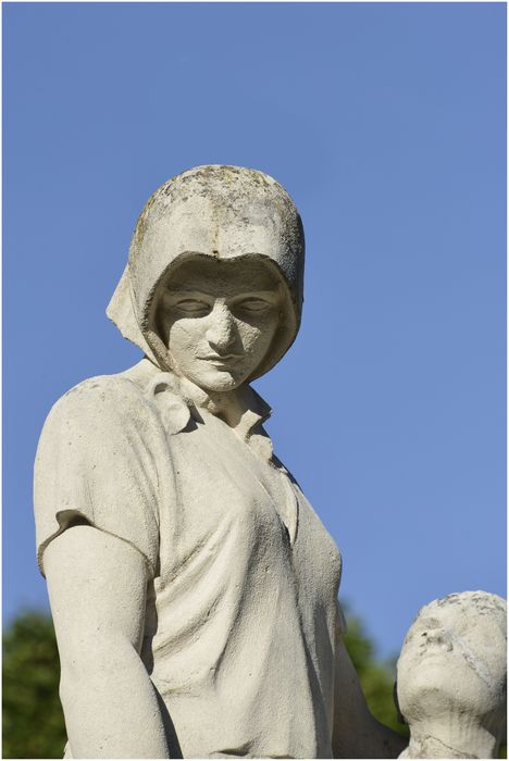 Groupe sculpté. Femme et enfant près d'une croix. Vue latérale. Détail.