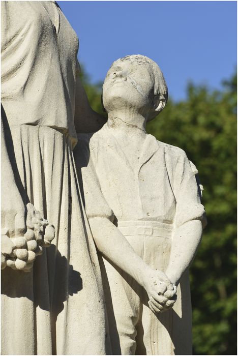 Groupe sculpté. Femme et enfant près d'une croix. Vue latérale. Détail.