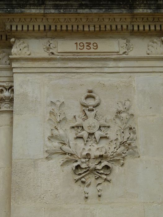 Pilier de gauche. Croix de guerre et branches de laurier.