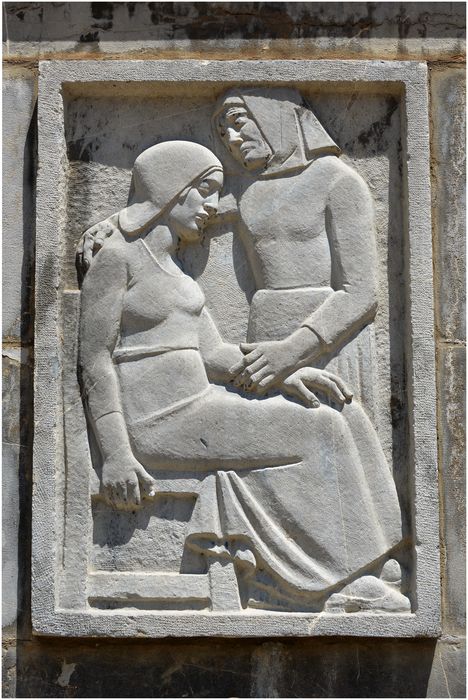 Bas-relief de gauche représentant une vieille femme debout consolant une jeune femme assise.