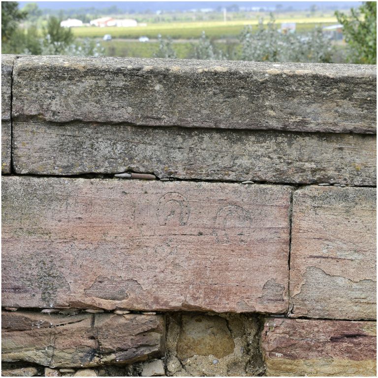 Pierres gravées de fers à cheval du parapet du pont.