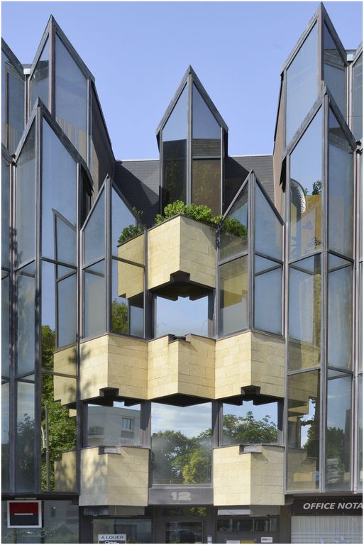Façade sur l’avenue. Partie centrale avec jeu des balcons en pierre et des verrières à angle aigu.