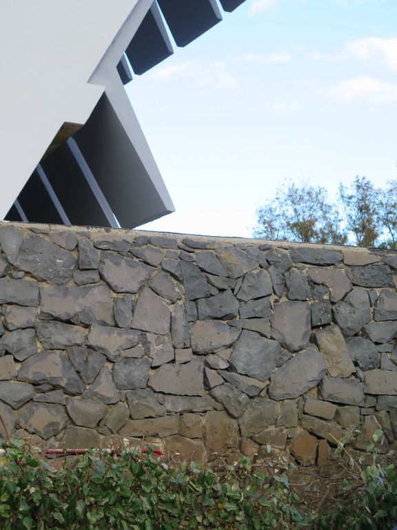 Extrémité sud-est de la résidence. Soubassement en basalte et débords des voiles de béton protégeant les coursives.