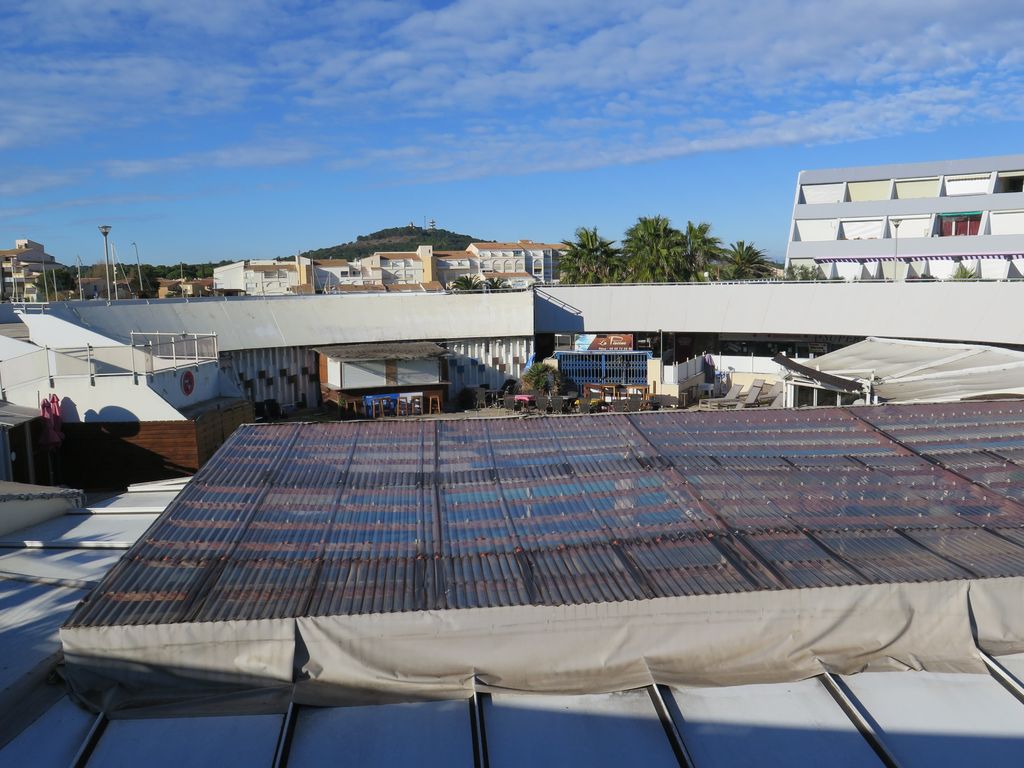 1er étage. Jardin suspendu. Vue sur le patio du rez-de-chaussée, partiellement obturé par les protections solaires des commerces.