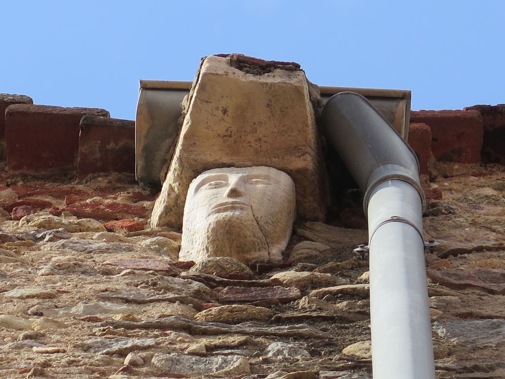 Mur sud. Tête sculptée, marbre, en remploi.