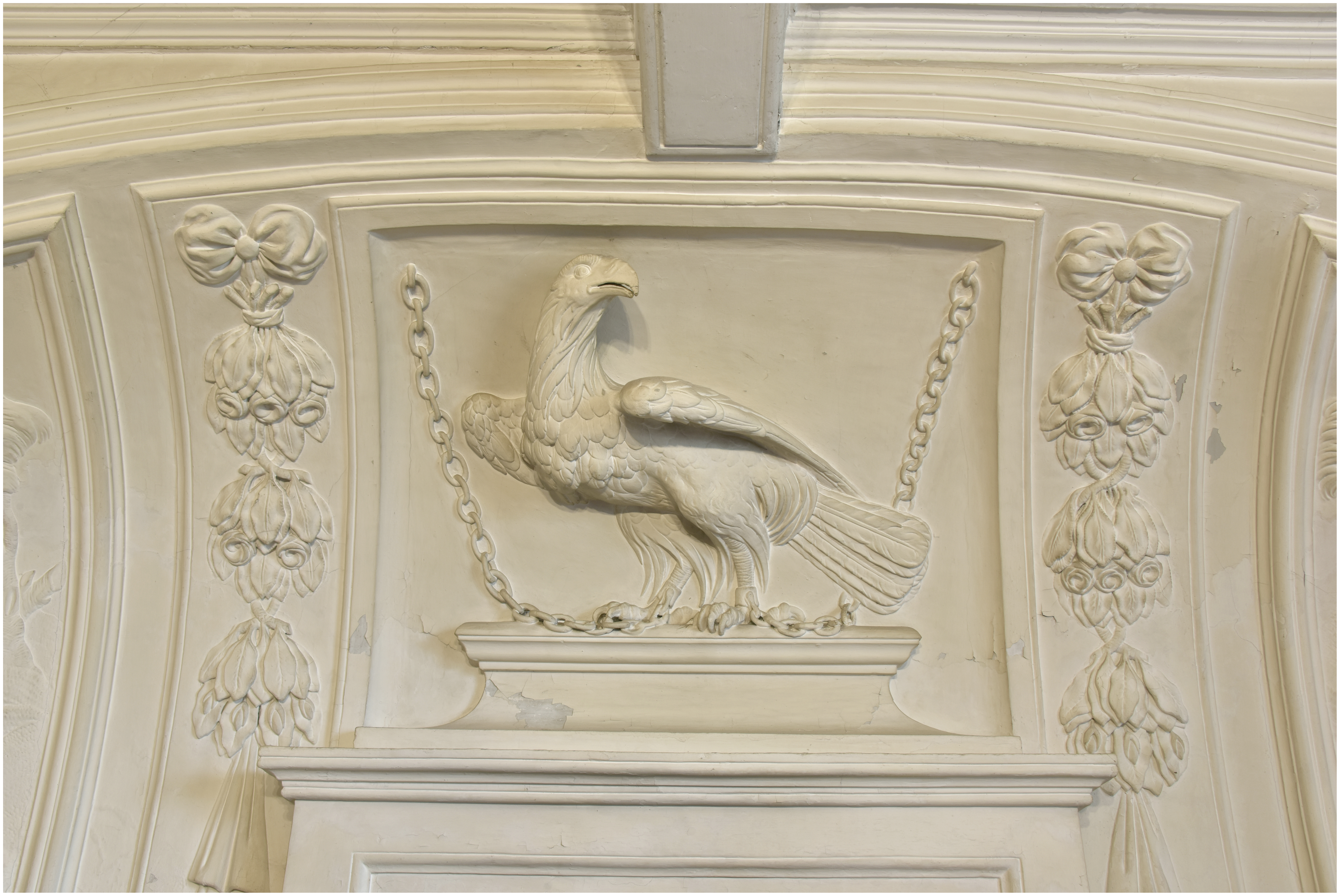 Salon, cheminée. Bas-relief : aigle enchainé encadré de chutes de bouquets de fleurs