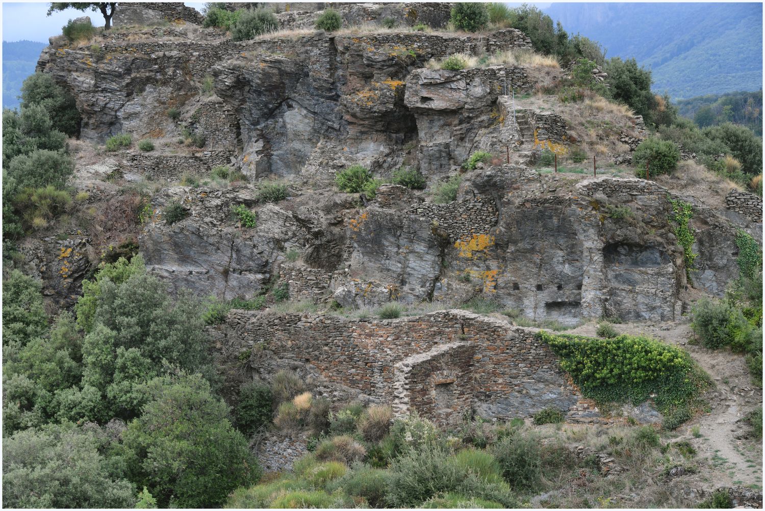 Vue de détail du pôle castral primitif, avec des habitations adossées au rocher.