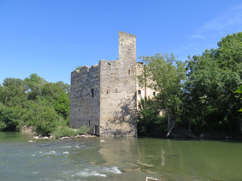 Le moulin de Canet, depuis la rive gauche de l’Aude (face nord et ouest). Dans le lit du fleuve, l’ancien moulin est un bâtiment hexagonal , avec une tour grenier.