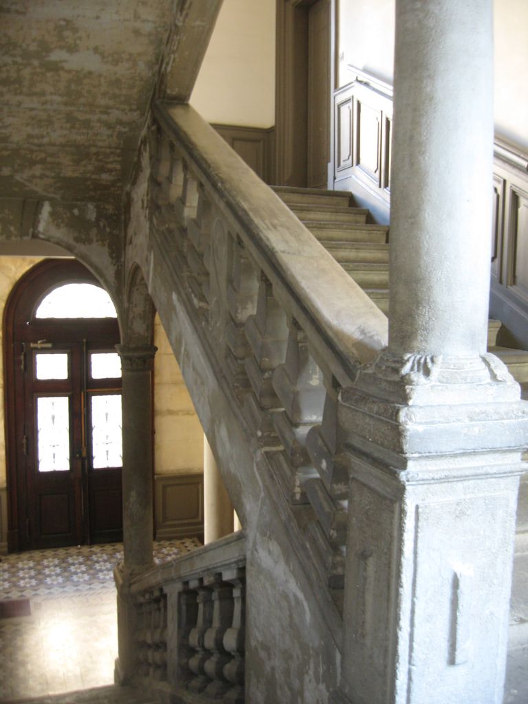 Grand escalier rampe sur rampe à balustres.