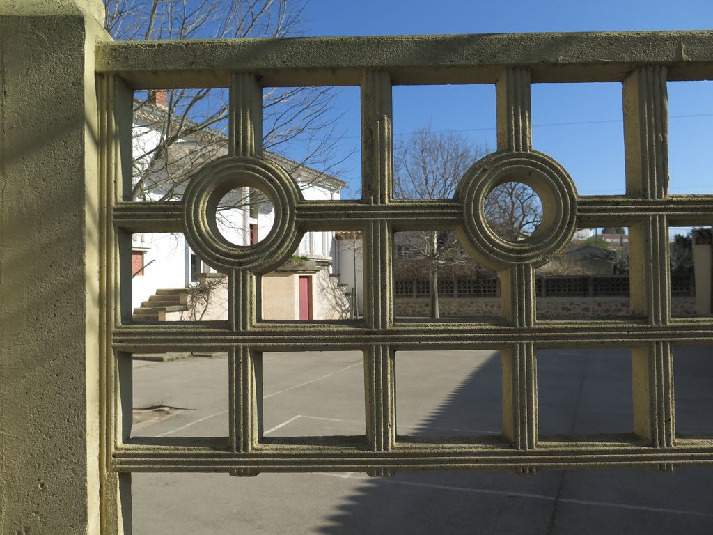 Mur de clôture de la cour de récréation. Détail motifs en béton moulé.
