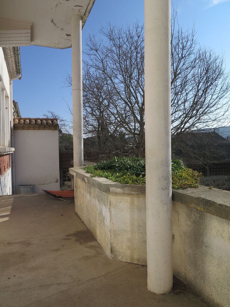 Façade sur la cour de récréation. Auvent et jardinière marquant l’accès à la cour depuis les classes.