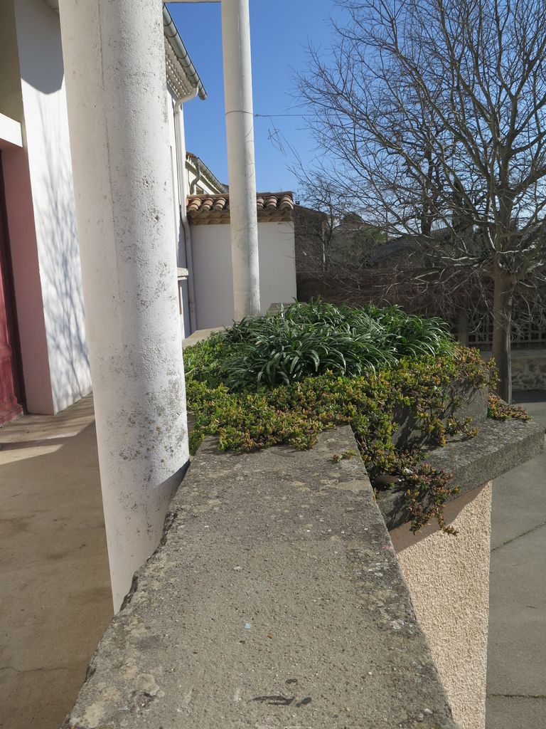 Façade sur la cour de récréation. Auvent et jardinière marquant l’accès à la cour depuis les classes.