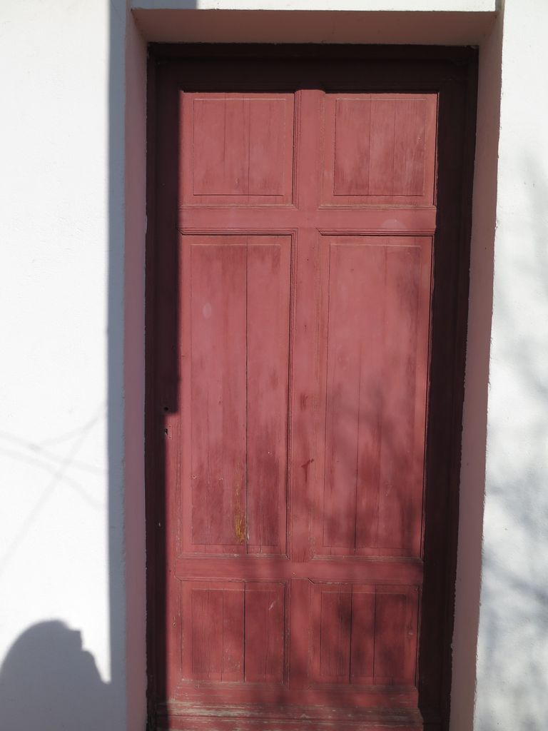 Façade sur la cour de récréation. Menuiserie bois d’origine de la porte d’accès des classes.