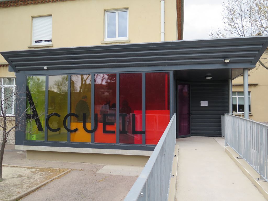 Façade sud. Cour de la maternelle. Pavillon d’accueil vitré ajouté en avant de la sculpture de Hubert Yencesse (1900-1987).