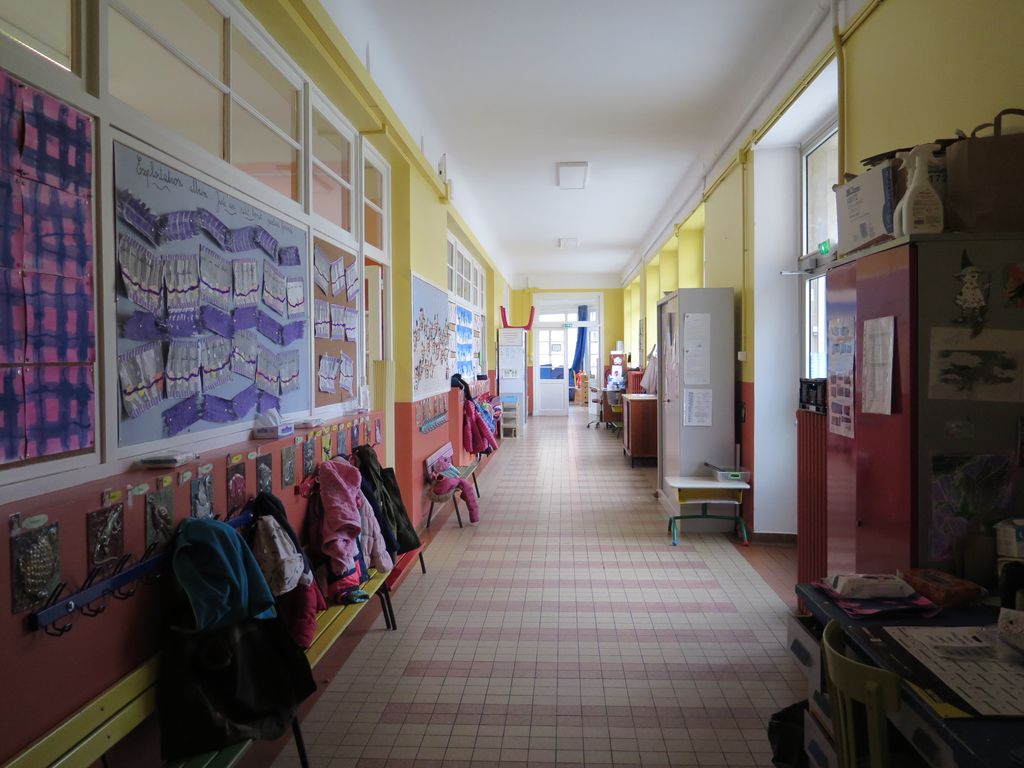 Couloir nord de la maternelle, avec les porte-manteaux ornés de céramiques de Yvonne Gisclard-Cau au titre du 1 % artistique.