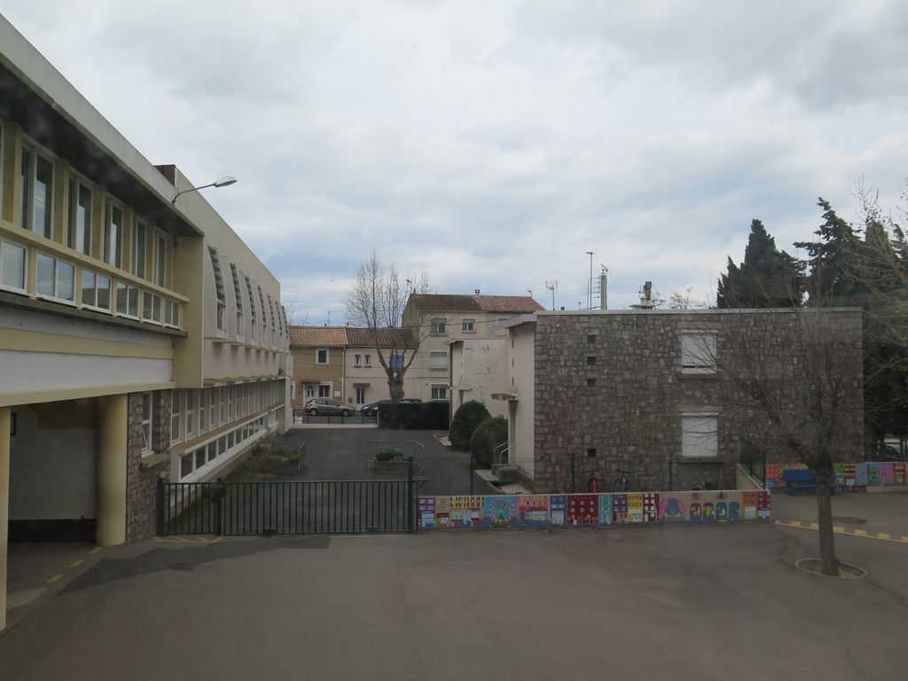 Depuis le groupe scolaire, vue des logements à droite et de la cantine à gauche.