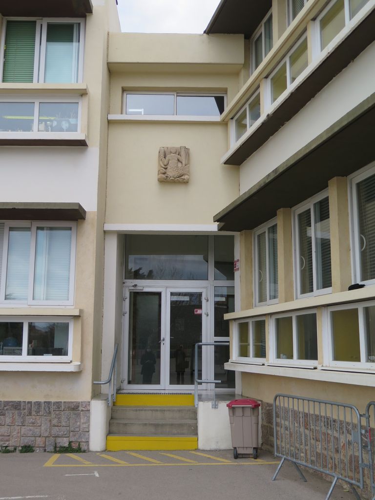 Entrée de l’aile ouest à la jonction des deux façades sur cour. Sculpture de Yvonne Gisclard-Cau. 