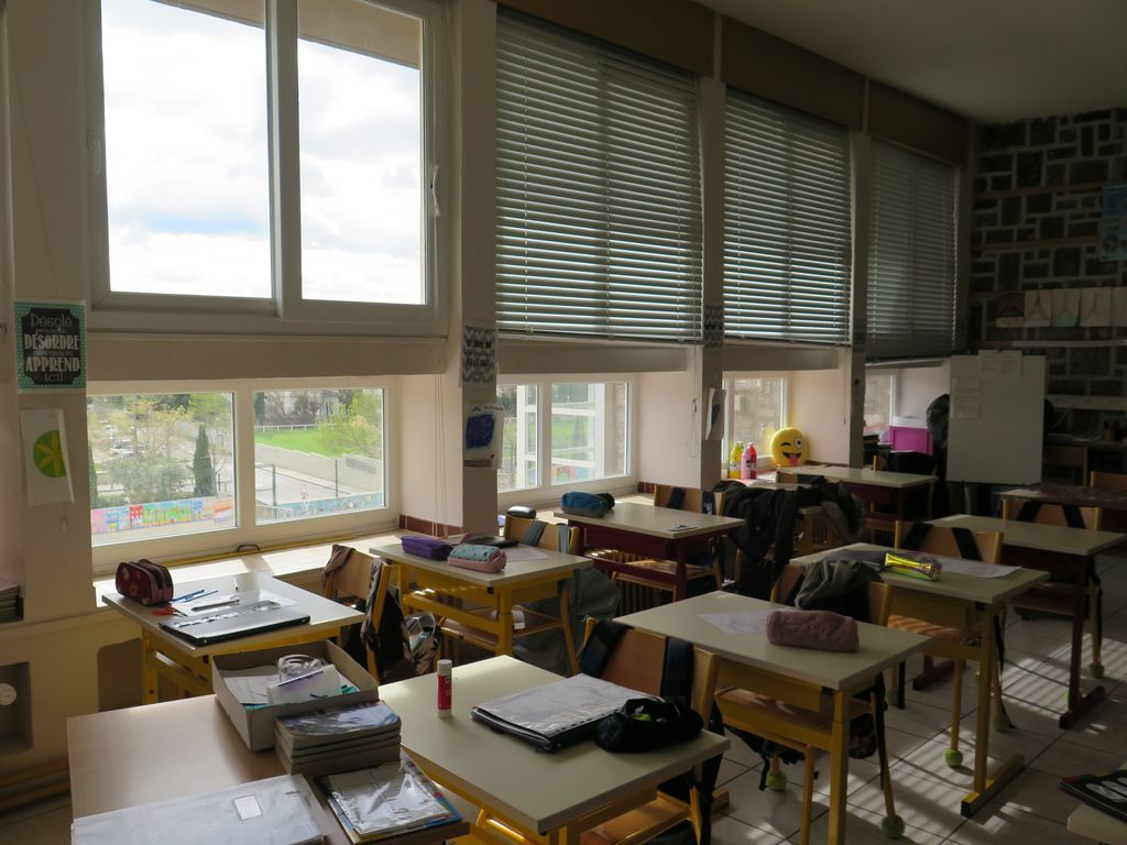 Salle de classe dont un des murs est en appareil de pierre.