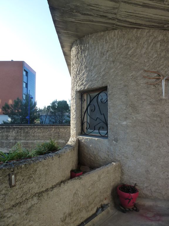 L’escalier donne sur une terrasse desservant les appartements du 1er étage. L’enduit volontairement épais et taloché est lié à la vocation agricole du bâtiment.