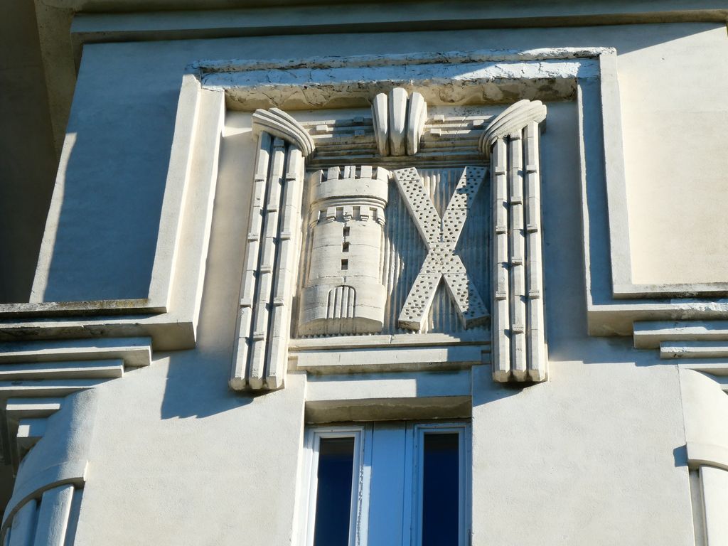 Façade principale sur rue. Pavillon central. Décor sculpté. Les armes de la ville.