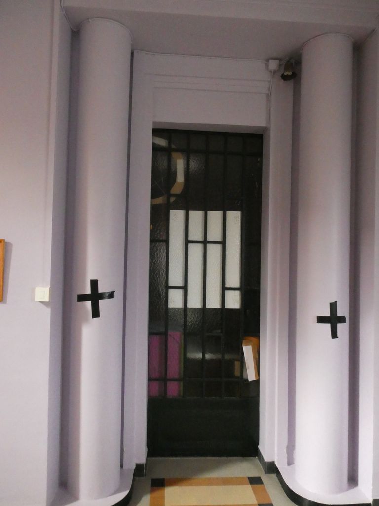 Intérieur. Porte métallique et carrelage à motifs carrés.