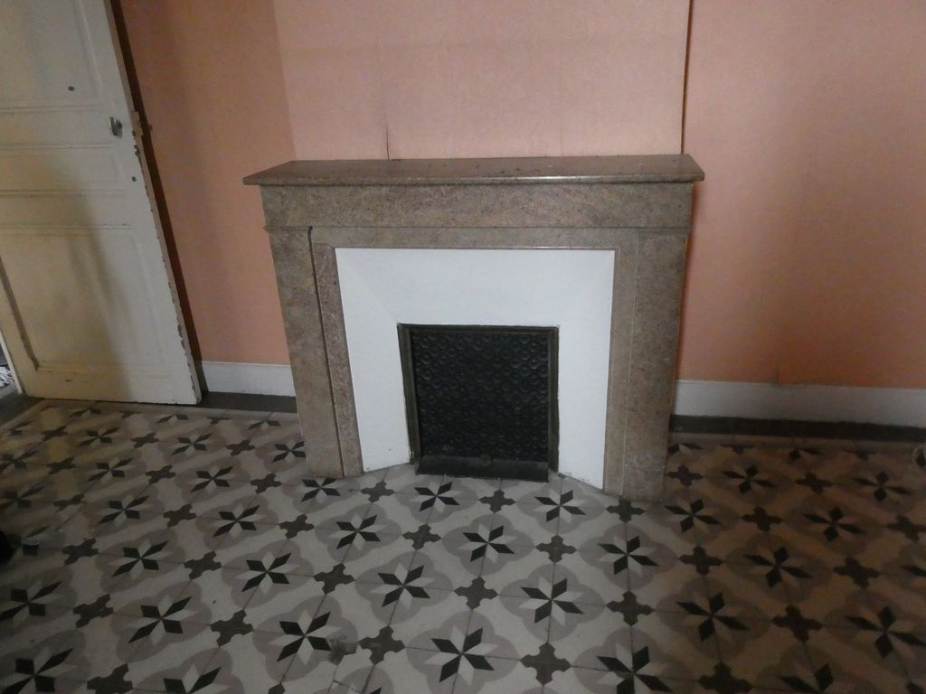 Logement. Cheminée en marbre et carreaux de ciment.