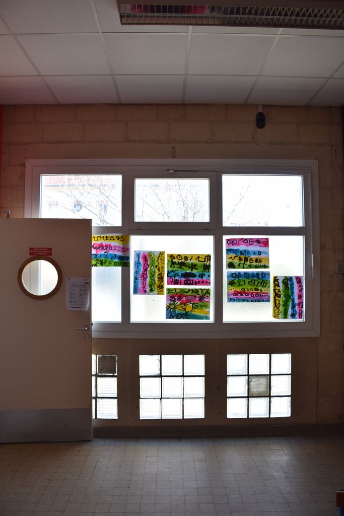 Ecole maternelle. Ensemble de menuiseries sur rue. Pavés de verre en partie basse.