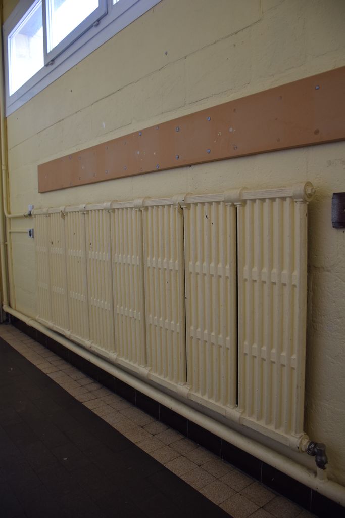 Ecole maternelle. Couloir des classes donnant sur la rue. Radiateurs.