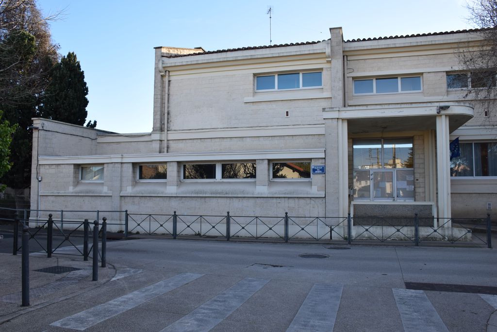 Ecole élémentaire Jean-Moulin. Côté école des garçons, avec porche en avancée abritant l’entrée.