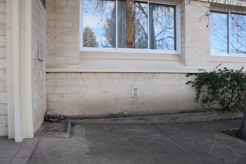 Ecole élémentaire Jean-Moulin. Façade sur rue. Détail des jardinières en bas de mur le long de la façade.