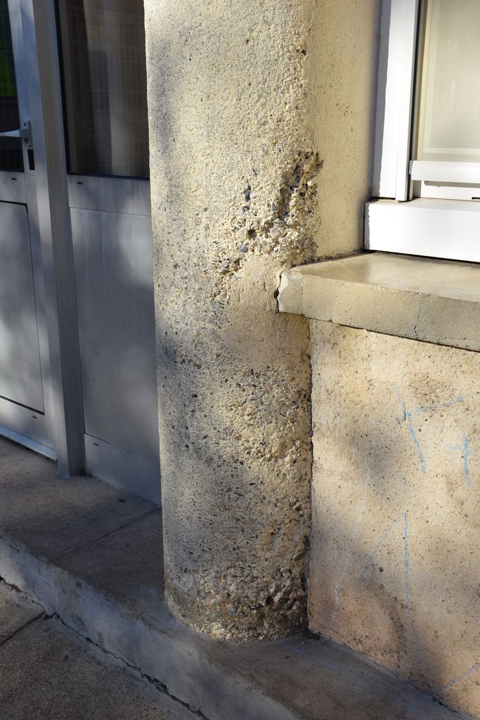 Ecole élémentaire Jean-Moulin. Façade sur la cour de récréation. Détail des piliers arrondis en béton.