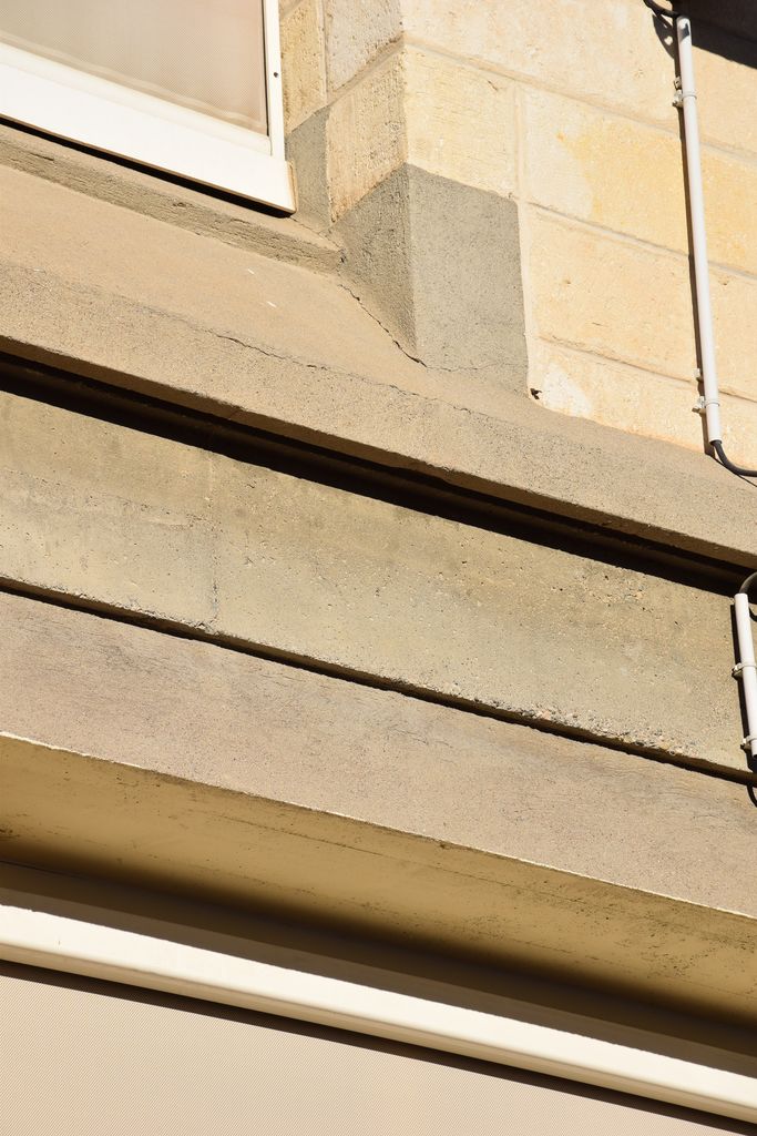 Ecole élémentaire Jean-Moulin. Façade sur la cour de récréation. Détail des corniches en béton.