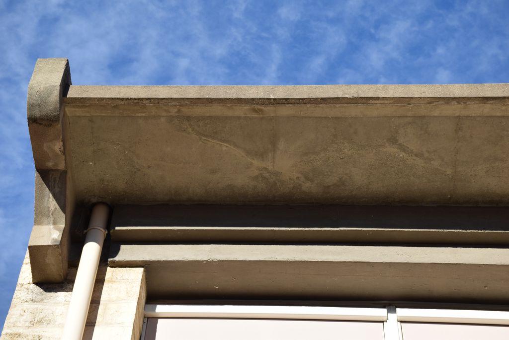 Ecole élémentaire Jean-Moulin. Façade sur la cour de récréation. Détail des corniches en béton.
