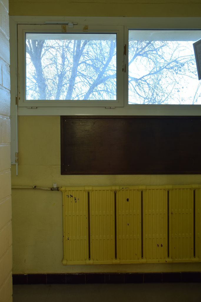 Ecole élémentaire Jean-Moulin. Couloir. Radiateur plat et tableau d’affichage en bois.